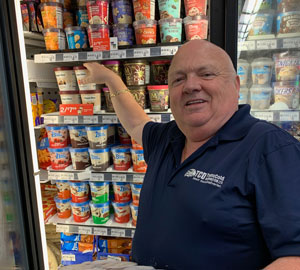John merchandising ice cream freezer in store